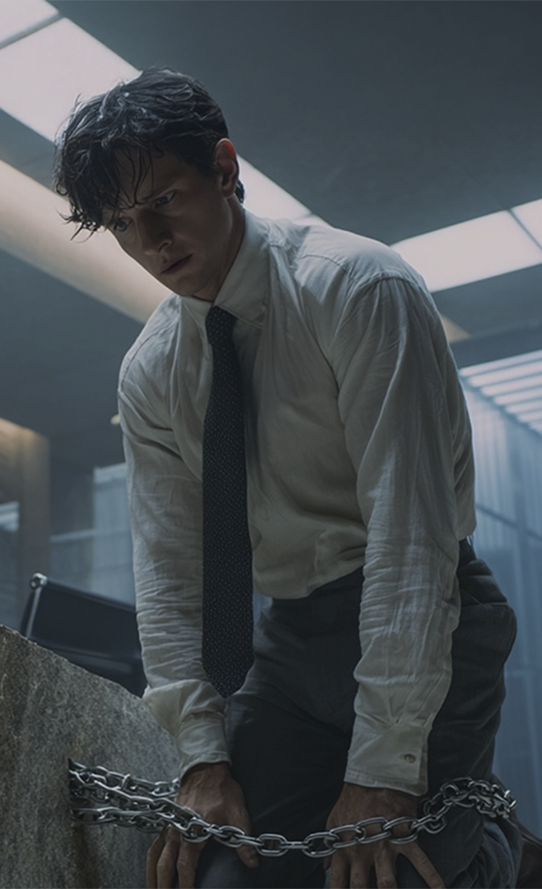 Symbolbild: Ein Mann ist in einem Büro an einen Stein gekettet